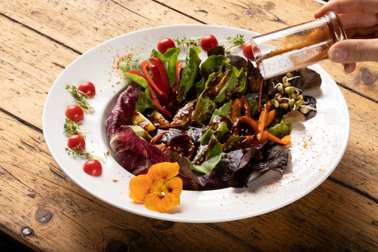 Salatdressing Vinaigrette Acetto Balsamico mit buntem Salatteller - Tomaten, Paprika, Blattsalat, Sprossen, Kapuzienergressse Blülüte